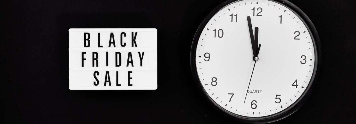 a black friday sale signage beside a black and white round analog wall clock