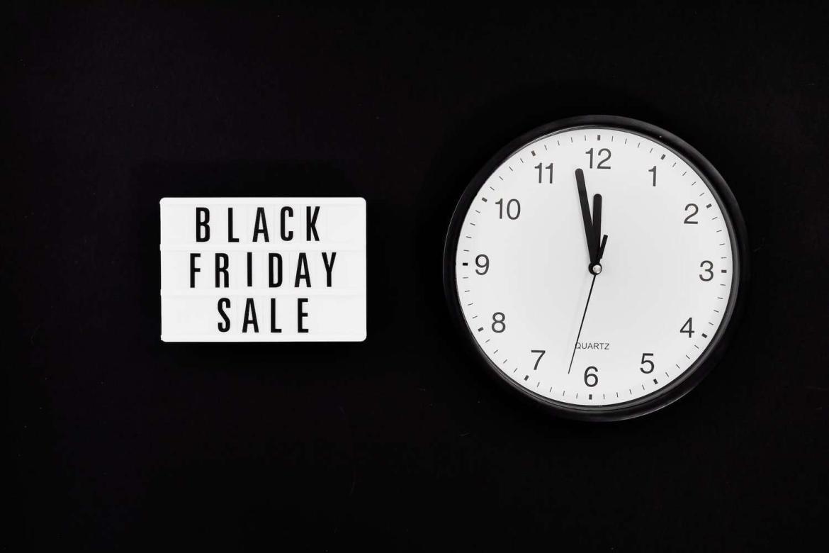 a black friday sale signage beside a black and white round analog wall clock