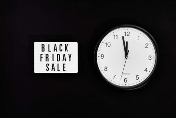 a black friday sale signage beside a black and white round analog wall clock